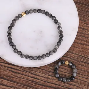 Detailaufnahme von 4mm grauem Blitzstein-Elastikarmband und Ring-Set mit Goldperlen