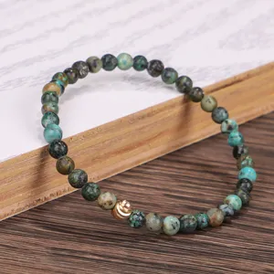 Elastisches Armband aus afrikanischem Türkisstein mit einem goldenen Perlenakzent