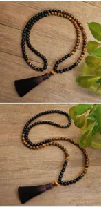 Dettaglio della collana Mala con 108 grani in occhio di tigre e pietra e nappa
