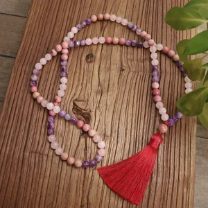 Dettaglio della collana di 108 perle in quarzo rosa e ametista con una grande nappa rossa