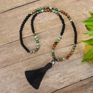 Dettaglio della collana mala con 108 perle in pietra naturale, occhio di tigre e nappina