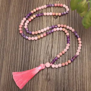 Detalle macro de collar mala yoga 108 cuentas de cuarzo rosa y amatista con borla rosa