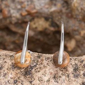 Makro-Detailaufnahme von Tigerauge-Steinperlen an silberfarbenen Ohrhängern.