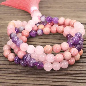 Detalle del collar mala yoga de 108 cuentas con cuarzo rosa y amatista púrpura con borla larga.