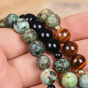 Primo piano di perle naturali occhio di tigre e turchese africano per gioielli yoga