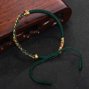Dettaglio del bracciale tibetano intrecciato a mano con perline in rame con mantra sei sillabe
