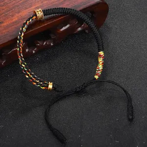 Dettaglio di un braccialetto tibetano intrecciato a mano con nodo Vajra e perla