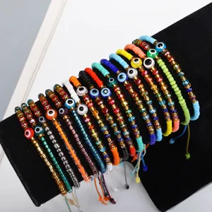 Detailansicht bunter Evil-Eye-Armbänder mit Kristallperlen auf einem schwarzen Schmuckständer.
