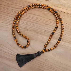 Vista dettagliata della collana con 108 perle occhio di tigre e nappa nera elegante