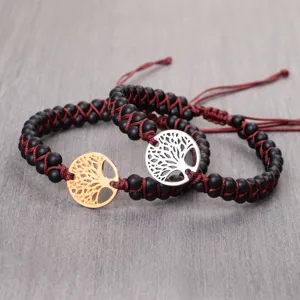 Detailed view of handmade matte black bead bracelets with gold and silver Tree of Life charms