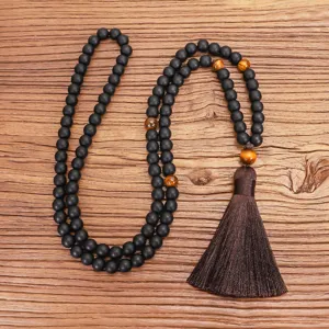 Textura detallada del collar mala de yoga con 108 cuentas negras mates y ojo de tigre.