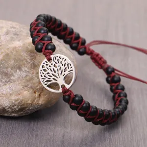 Detail of handmade Tree of Life bracelet with matte black beads and burgundy woven cord.