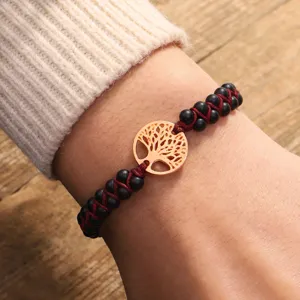 Detail view of handmade braided bracelet with matte stone beads and Tree of Life charm