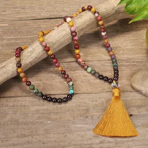 Detailed macro view of 108 stone beads necklace with a vibrant yellow silk tassel