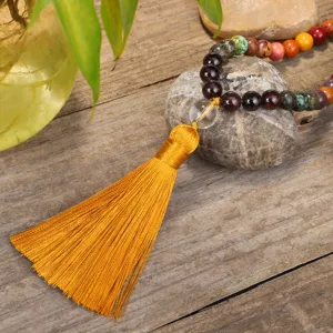 Macro detail view of a 108 stone bead mala necklace with a vibrant long yellow tassel