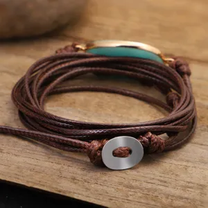 Dettaglio del bracciale fatto a mano in amazzonite con cordoncino cerato marrone multistrato.