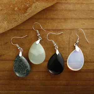 Set orecchini boho a goccia con pietre naturali su fondo in legno rustico
