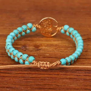 Detailweergave van de handgeweven turquoise kralenarmband met gouden levensboom hanger
