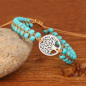Gedetailleerde close-up van turquoise kralenarmband met zilveren Tree of Life bedel