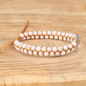 Detailweergave van handgemaakte yoga-armband met witte turkoois kralen en levensboom-charme