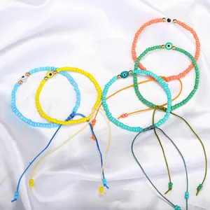 Handgemachte bunte Perlenarmbänder mit bösem Blick Glasanhängern auf weißem Seidenstoff