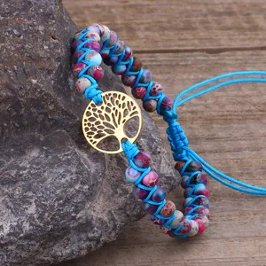 Primo piano di un bracciale in pietra imperiale intrecciata con Albero della Vita d'oro