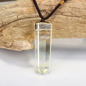 Detail shot of a natural citrine hexagonal column crystal pendant with a dark woven rope.