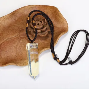 Detailed view of yellow crystal hexagonal prism pendant with brown woven rope
