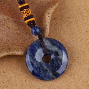 Detailaufnahme eines blauen Sodalith-Steins Ping An Kou Anhängers mit Kordelkette
