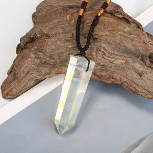 Close-up of a faceted hexagonal crystal pendant on a brown braided cord necklace