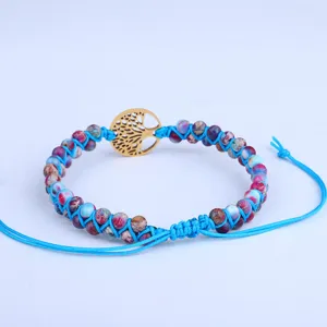 Dettaglio del bracciale intrecciato a doppio strato con pietre e ciondolo albero della vita