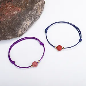 Detailansicht der Lavasteinperle auf verstellbarem, geflochtenem Wachskordelarmband