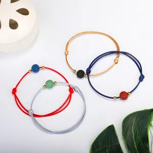Detailansicht von Yoga-Armbändern aus gewachster Kordel mit Lavastein und Kupferperlen.