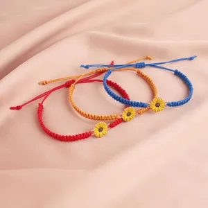 Nahaufnahme von drei böhmischen Sonnenblumenarmbändern aus bunt gewachstem Faden.