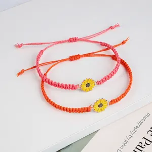 Detailansicht der handgefertigten gewebten Armbänder in Pink und Orange mit Sonnenblumen