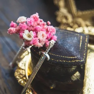 Detailed macro shot of vintage S925 sterling silver sword brooch with pink flowers