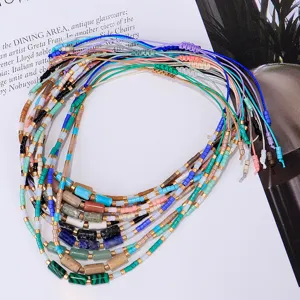 Detailansicht von bunten handgewebten Perlenarmbändern mit zylindrischen Steinperlen