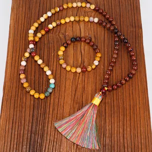 Vue détaillée du collier et bracelet MALA 108 pierres fait main pour le yoga sur bois.