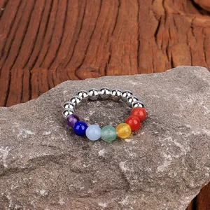 Detailansicht eines 4mm Naturstein-Elastic-Rings mit Regenbogen-Chakra-Perlen auf einem Fels
