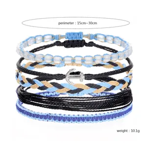 Detailed view of bohemian wax thread bracelet set with silver anchor charm and braids
