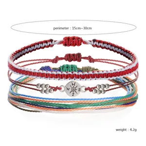 Close-up of bohemian woven wax thread bracelet set with compass charm detail