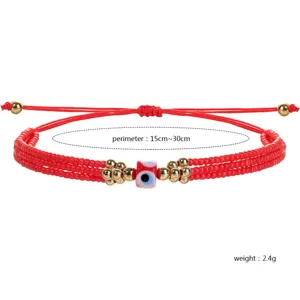 Detalle de pulsera ajustable de cuentas rojas con amuleto de ojo turco y toques dorados