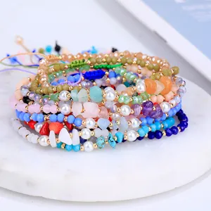 Primer plano de pulseras de colores tejidas a mano con perlas y cristales para mujer.