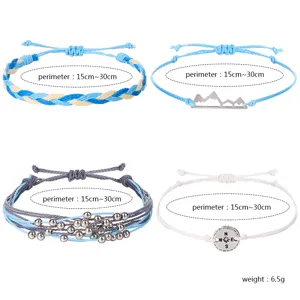 Detailliertes Set aus vier handgefertigten Wachskordelarmbändern mit Berg- und Kompassanhängern