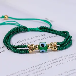 Primer plano de una pulsera de cuentas verdes de varias capas con amuleto de ojo turco.