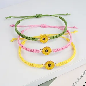 Detailansicht handgefertigter gewebter Boho-Sonnenblumenarmbänder in Grün, Rosa und Gelb