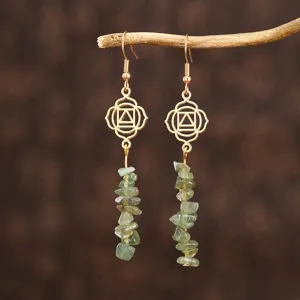 Gros plan détaillé de boucles d'oreilles pendantes faites main avec cristaux verts et mandalas