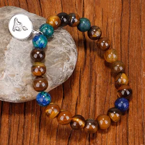 Bracelet en perles d'œil de tigre avec breloque bouddha sur fond rustique bois et pierre