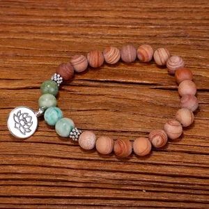 Détail d'un bracelet en perles de pierre veinée de bois fait main avec breloque lotus