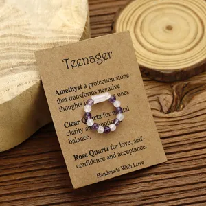 Detail of handmade beaded ring with amethyst and clear quartz on a kraft gift card
